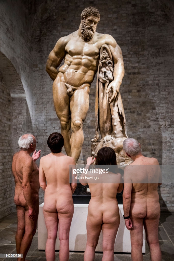 A group of naturists admire a nude cast of Hercules during a ...