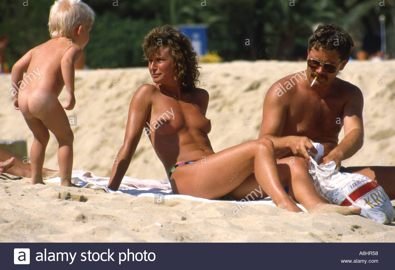 Family on the beach at Magalluf with nude child talking to ...