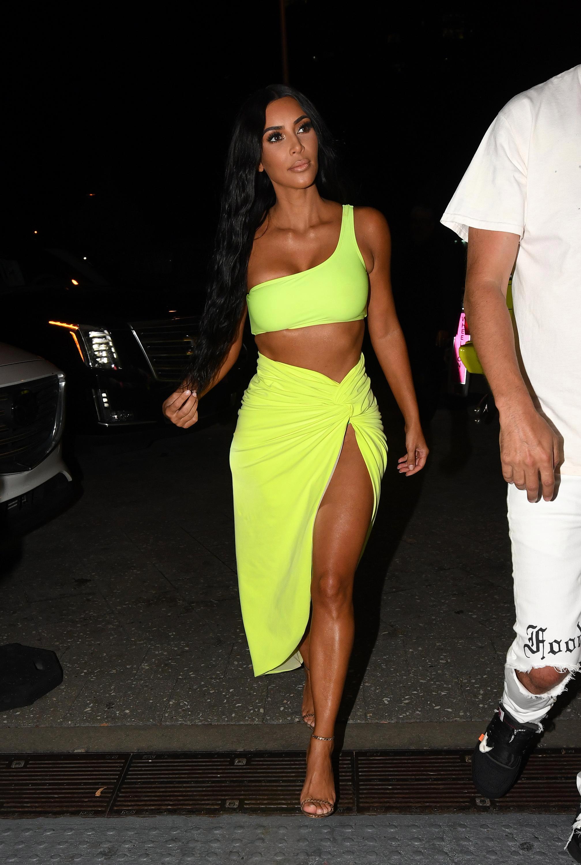 Kim Kardashian flashes her legs in a thigh-split skirt and neon ...